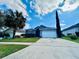 Charming single-story home with well-manicured lawn, palm trees, and attached two-car garage at 2663 Oneida Loop, Kissimmee, FL 34747