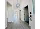 Foyer with gray wood-look flooring, and view of the living room at 2663 Oneida Loop, Kissimmee, FL 34747