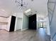 Bright living room featuring modern light fixture, skylight, and gray wood-look flooring at 2663 Oneida Loop, Kissimmee, FL 34747