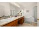 Bright bathroom with double sinks, large mirror, tub, and shower at 301 Wingdale Way, Davenport, FL 33897