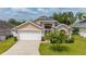Charming home with a well-manicured lawn, palm trees, and a two-car garage, offering curb appeal at 301 Wingdale Way, Davenport, FL 33897