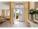 Bright foyer with tile flooring, decorative columns, and a view into the formal living area at 301 Wingdale Way, Davenport, FL 33897