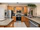 Well-lit kitchen features stainless steel appliances, granite countertops, and wood cabinets at 301 Wingdale Way, Davenport, FL 33897