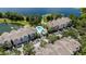 Stunning aerial view of the community featuring a pool, parking, and beautiful lake views at 3344 Corona Village Way # 207, Orlando, FL 32835