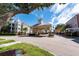 Welcoming community entrance with a clock tower, manicured landscaping, and secure gated access at 3344 Corona Village Way # 207, Orlando, FL 32835