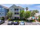 Two-story condo features a screened balcony, palm trees, and dedicated parking spots at 3344 Corona Village Way # 207, Orlando, FL 32835