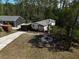 Aerial view of a home with an extended driveway, and landscaped yard, and detached garage in a wooded setting at 3669 General Marshall Rd, Daytona Beach, FL 32124