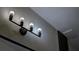 A modern bathroom light fixture with clear glass shades and energy-efficient lighting at 3669 General Marshall Rd, Daytona Beach, FL 32124
