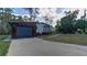Home exterior with two-car garage, complemented by lush landscaping and concrete driveway at 3669 General Marshall Rd, Daytona Beach, FL 32124