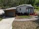Charming home exterior view, featuring a garage and beautiful landscaping with colorful plants at 3669 General Marshall Rd, Daytona Beach, FL 32124