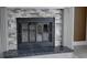 The fireplace is adorned with stone, featuring an elegant black frame and hearth at 3669 General Marshall Rd, Daytona Beach, FL 32124