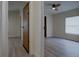 Hallway view leading into a bedroom with a ceiling fan and natural light at 3669 General Marshall Rd, Daytona Beach, FL 32124