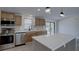 Well-lit kitchen featuring stainless steel appliances, light wood cabinets, and a quartz-topped island at 3669 General Marshall Rd, Daytona Beach, FL 32124