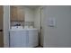 Convenient laundry room with washer, dryer, and overhead storage cabinets at 3669 General Marshall Rd, Daytona Beach, FL 32124