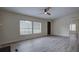 Bright living room featuring luxury vinyl floors, ceiling fan, and natural light from two windows at 3669 General Marshall Rd, Daytona Beach, FL 32124