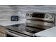 Close up of the electric stove with light quartz countertops and modern tile backsplash at 3669 General Marshall Rd, Daytona Beach, FL 32124