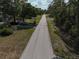 Street view showcasing the neighborhood with a paved road lined by trees at 3669 General Marshall Rd, Daytona Beach, FL 32124