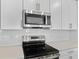 Close-up of a kitchen boasting stainless steel appliances, white subway tile backsplash, and sleek countertops at 3773 Deer Ridge Dr, Mount Dora, FL 32757