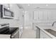 Bright kitchen boasting white cabinets, a center island with sink, and stainless steel oven and microwave at 3773 Deer Ridge Dr, Mount Dora, FL 32757
