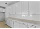 Spacious kitchen featuring white cabinets, sleek countertops, and stainless steel hardware, with backsplash at 3773 Deer Ridge Dr, Mount Dora, FL 32757