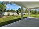 Covered patio overlooking expansive backyard with lush lawn and privacy fence at 3773 Deer Ridge Dr, Mount Dora, FL 32757