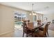 Elegant dining room with a wooden table set and sliding glass doors that lead to a screened-in pool area at 410 Canna Dr, Davenport, FL 33897