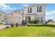 Charming two-story home features a well-manicured lawn and an attached two-car garage at 410 Canna Dr, Davenport, FL 33897