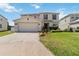 Charming two-story home features a well-manicured lawn and an attached two-car garage at 410 Canna Dr, Davenport, FL 33897