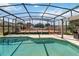 Screened-in pool area with a deck, blue tile lined pool, and seating at 410 Canna Dr, Davenport, FL 33897