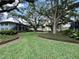 A lovely common area with mature landscaping, green grass, and walking paths at 4820 Conway Rd # 130, Orlando, FL 32812