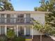 Charming two-story condo featuring gray paint, a balcony, and a well-maintained front yard with mature landscaping at 4820 Conway Rd # 130, Orlando, FL 32812
