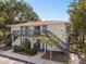 Two-story condo building with gray stairs and balcony surrounded by mature trees at 4820 Conway Rd # 130, Orlando, FL 32812