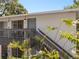 A view of the condo front with a stairway leading to the door and a small balcony with seating at 4820 Conway Rd # 130, Orlando, FL 32812