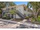 Two-story condo building with gray stairs and balcony surrounded by mature trees at 4820 Conway Rd # 130, Orlando, FL 32812