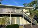 Two story condo with a private second story balcony, front door, and stairwell at 4820 Conway Rd # 130, Orlando, FL 32812