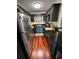Galley kitchen featuring stainless steel appliances, black countertops, and hardwood floors at 4820 Conway Rd # 130, Orlando, FL 32812