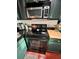 Cozy kitchen features black appliances and countertops with dark green cabinetry at 4820 Conway Rd # 130, Orlando, FL 32812