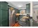 Modern kitchen with stainless steel appliances, sleek countertops, and painted green cabinetry at 4820 Conway Rd # 130, Orlando, FL 32812