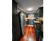 Galley kitchen featuring stainless steel appliances, black countertops, and hardwood floors at 4820 Conway Rd # 130, Orlando, FL 32812