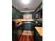 Galley kitchen featuring stainless steel appliances, black countertops, and hardwood floors at 4820 Conway Rd # 130, Orlando, FL 32812