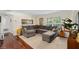Bright living room featuring hardwood floors, a large grey sectional sofa, and plenty of natural light at 4820 Conway Rd # 130, Orlando, FL 32812