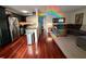 Open-concept living room and kitchen featuring hardwood floors, comfortable seating, and modern appliances at 4820 Conway Rd # 130, Orlando, FL 32812