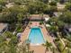 Overhead view of a community pool, outdoor lounge chairs, palm trees, and lush landscaping at 4820 Conway Rd # 130, Orlando, FL 32812