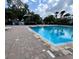 Community pool with cool, blue water and brick paver surround is a great place to relax at 4820 Conway Rd # 130, Orlando, FL 32812