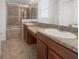Bathroom featuring double sinks with granite countertops, tiled floors, and a glass door shower at 4909 Terrapin Blvd, St Cloud, FL 34771
