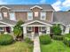 Attractive townhome showcasing a cozy front porch with stone accents and lush greenery at 4909 Terrapin Blvd, St Cloud, FL 34771