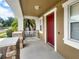 Spacious front porch with stone accents and a red door, offering a cozy entrance at 4909 Terrapin Blvd, St Cloud, FL 34771