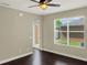 Bright living room with dark wood floors, ceiling fan, and a glass door to the outside at 4909 Terrapin Blvd, St Cloud, FL 34771