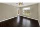 Bright living room with dark wood floors, ceiling fan, a window, and a glass door to the outside at 4909 Terrapin Blvd, St Cloud, FL 34771
