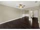 Spacious living room featuring dark hardwood floors and an open layout with ceiling fan at 4909 Terrapin Blvd, St Cloud, FL 34771